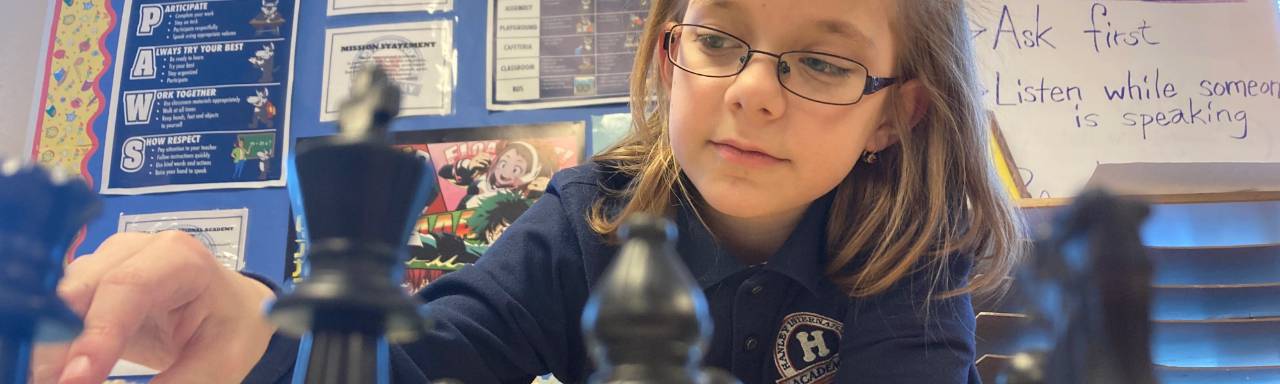 A middle school girl plays chess